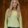 Front view of model wearing The Heather Ribbed Long Sleeve Top in Lime features lime green knit fabric, textured details, thick hem, round neckline, dropped shoulders and long balloon sleeves with cuffs.