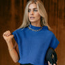 Front view of model wearing the Alexandra Cobalt Blue Sleeveless Sweater that has cobalt blue ribbed knit fabric, ribbed hem, high neckline and sleeveless.