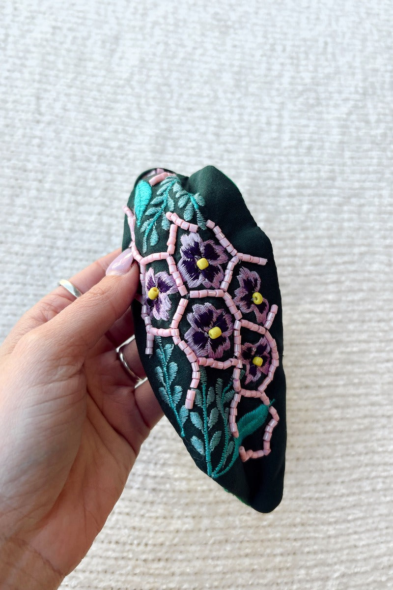 Side view of the Flower Power Headband which features emerald coloring fabric, turquoise and purple stitching, floral pattern with pink and yellow beads.