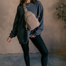 Full body view of model wearing the Vira Black Long Sleeve Sweatshirt which features washed black knit fabric, a round neckline, dropped shoulders, and long sleeves with cuffs.