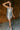 Full body front view of model wearing the Elia Silver Sequin Sleeveless Mini Dress that has light grey knit fabric covered in silver mirror sequins, silver lining, mini length, a v-neckline, and halter spaghetti straps.