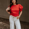 Front view of model wearing the Maddie Red Puff Sleeve Top that features red cotton fabric, a round neckline, and short bubble puff sleeves.