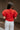 Back view of model wearing the Maddie Red Puff Sleeve Top that features red cotton fabric, a round neckline, and short bubble puff sleeves.