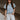 Front view of model wearing the Cynthia Blue Short Sleeve Button Up Top that has light blue tencel fabric, light brown stitching , grey tortoise buttons, a collared neckline, and short flare sleeves.