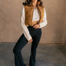 Full body front view of model wearing the Sutton Brown Cropped Puffer Vest that has light brown puffer fabric, 3 tiered design, a cropped waist, pockets, a zipper, a drawstring at the waist, a high neck and a sleeveless design.