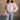 front view of model wearing the Charlotte Light Pink Raglan Sweatshirt that has light dusty pink knit fabric, raw hem details, a round neckline, and long wide sleeves.