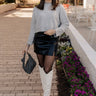 Full body front view of model wearing the Emily Grey Cropped Long Sleeve Sweater that has heather grey knit fabric, ribbed hem, cropped waist, a high neck, dropped shoulders, and long sleeves.