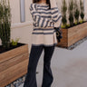 Full body front view of model wearing the Kelly Cream & Grey Striped Long Sleeve Sweater that has cream and grey knit fabric with a striped pattern, a ribbed hem, a round neckline, and long sleeves with ribbed cuffs.