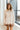 Front view of model wearing the New You Striped Sweater that has a cream and light brown striped pattern, a light brown ribbed high-low hem, a cowl neckline, and long sleeves with light brown ribbed wrists.