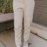 Front view of model wearing the Let's Chill Jogger Pants that have khaki knit fabric, a two-tone ribbed waistline, waist ties, side pockets and jogger legs with a two-tone ribbed hem