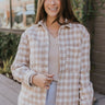 Front view of model wearing the Yours Truly Shacket in Beige that has a beige and cream checkered pattern, a button-up front with silver buttons, two front chest pockets, two side pockets, a collar, and long sleeves.