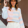 Front view of model wearing the Beautiful Day Striped Sweater that has peach, light blue and light pink knit fabric with stripes, a color block pattern, a cropped waist, ribbed trim, a round neck and long sleeves.