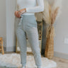 Front view of model wearing the Everyday Dreams Pants which features heather grey fabric, two side pockets, an elastic drawstring waist, and jogger legs with elastic ankles.