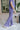 Side view of model wearing the Wanderlust Pants that feature purple plisse fabric, an elastic waistband, and wide legs with lettuce trim