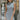 Front view of model wearing the Call Me Later Sweater Dress that has grey knit fabric, a mini length hem, a loose turtleneck, and a sleeveless body.
