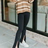 Front view of model wearing the Comfort Zone Flared Leggings that have soft black fabric, an exposed seam down the pant leg, and flared legs with front slits