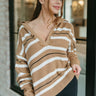 Front view of model wearing the For The Record Sweater that has camel knit fabric with a cream and black stripe pattern, a v neckline with a folded collar, frayed detais, and long balloon sleeves.