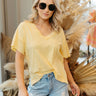 Front view of model wearing the Need More Time Top in Yellow which features yellow cotton fabric, slits on each side of the hem, a v-neckline, and short sleeves.