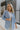 Front view of model wearing the Once Upon A Time Blazer which features light blue fabric, two front pockets, a collared neckline, and 3/4 sleeves with ruched details.