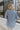 Side view of model wearing the Once Upon A Time Blazer which features light blue fabric, two front pockets, a collared neckline, and 3/4 sleeves with ruched details.