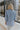 Back view of model wearing the Once Upon A Time Blazer which features light blue fabric, two front pockets, a collared neckline, and 3/4 sleeves with ruched details.