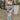 Front view of model wearing the In Bloom Midi Dress that has white fabric with a purple, blue, green and pink watercolor floral design, ruching, a v-neck, thick straps, a a side slit, and a lining