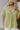 Close up view of model wearing the Need A Getaway Top which features lime green fabric, a v neckline with a collar, and short sleeves with cuffs.