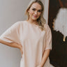 Front view of model wearing the Just A Dream Top in Peach which features peach cotton fabric, a round neckline, an oversized fit, and short sleeves.