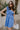 Front view of model wearing the Phoebe Blue One- Shoulder Smocked Mini Dress which features blue light weight fabric, mini length, blue lining, upper smocked details, ruffle details, one shoulder ruffle strap and sleeveless.