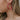 Close up view of model wearing the Hot Summer Earring which features hot pink large hoop shaped earring with roping details.