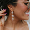 Close up view of model wearing the Upstate Pearl Earring which features squares of pearls linked to each other with a dangle effect and set in gold.