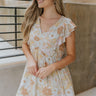 Front view of model wearing the Love You Always Dress that has a light sage, pink, blue, mustard and rust floral pattern, lined fabric, a babydoll style, a v-neckline, and short sleeves with ruffles.