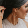 Close up view of model wearing the Faithful Looks Hoop Earrings which features open large gold beaded hoops.