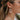 Close up view of model wearing the It Comes Natural Earrings which features green marble oval shaped hoop linked with a natural marble oval shaped hoop.