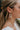 Close up view of model wearing the It Comes Natural Earrings which features green marble oval shaped hoop linked with a natural marble oval shaped hoop.