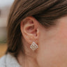 Close up view of model wearing the Ready To Go Earrings which features mini gold, closed hoops with a cluster of clear stones.