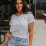 Front view of model wearing the Lounge Life Top in White which features off white fabric, a v-neckline, and short sleeves.