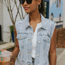 Front view of model wearing the Good For You Denim Vest that has light wash denim fabric, a cropped waist, silver buttons, a collar, front chest pockets, and distressed detailing, light brown stitching.