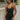 Front view of model wearing the Call It Even Romper that features black stretch fabric, a romper body, a round neckline, bra padding, and adjustable spaghetti straps.