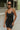 Front view of model wearing the Call It Even Romper that features black stretch fabric, a romper body, a round neckline, bra padding, and adjustable spaghetti straps.