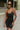Front view of model wearing the Call It Even Romper that features black stretch fabric, a romper body, a round neckline, bra padding, and adjustable spaghetti straps.