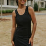 Front view of model wearing the Back to Back Dress which features black fabric with a monochromatic stripe design, a mini-length hem, small front slits, bra padding, a round neckline, a sleeveless design, and black lining.