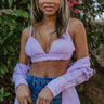 Front view of model wearing the Laguna Seersucker Bralette in Pink that has a pink and white striped seersucker pattern, adjustable spaghetti straps, and a back tie closure