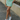 Front view of model wearing the Take Me Higher Skirt which features green and light blue knit fabric with a checkered pattern, mini length, a small front slit, and an elastic waistband.