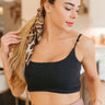Front view of model wearing the Maybe Next Time Tank that has black textured fabric, a cropped waist, a scooped neckline, and adjustable spaghetti straps.