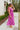 Side view of model wearing the Love Like Ours Midi Dress that has orchid pink textured fabric, midi length, a ruffle tiered hem, a smocked waistband, a square neckline with ruffle trim, ruffle straps, an open back, and a drawstring tie closure