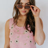 Front view of model wearing the Picking Daisies Top in Pink that has light pink crochet knit fabric with a cream daisy pattern, a cropped waist, scalloped hem, a scoop neck, and thick straps.
