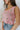 Close side view of model wearing the Picking Daisies Top in Pink that has light pink crochet knit fabric with a cream daisy pattern, a cropped waist, scalloped hem, a scoop neck, and thick straps.