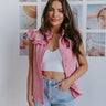 Front view of model wearing the Hidden Romance Top which features pink washed denim fabric, light tortoise buttons, a high neckline, ruffle details, and a sleeveless design.