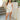 Full body front view of model wearing the Great Escape Overalls that have cream denim fabric, pockets, silver buttons, belt loops, a square neckline, adjustable straps, and distressed details